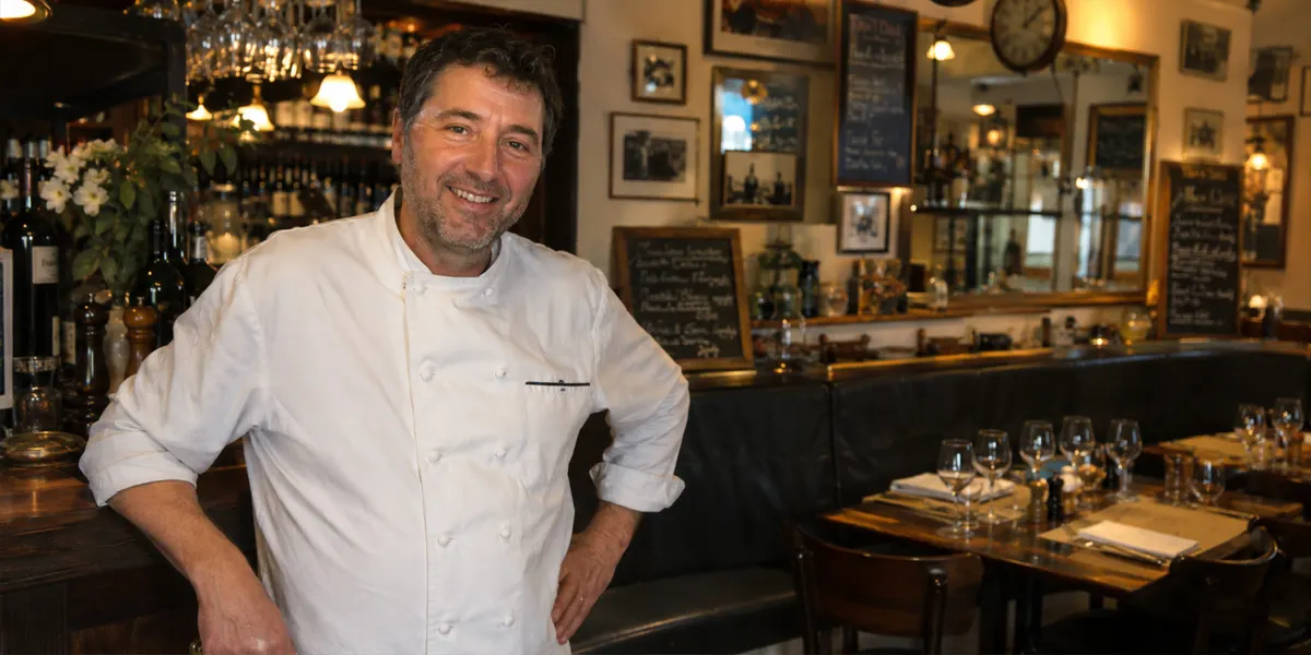 Restaurateur en veste de cuisine dans son établissement